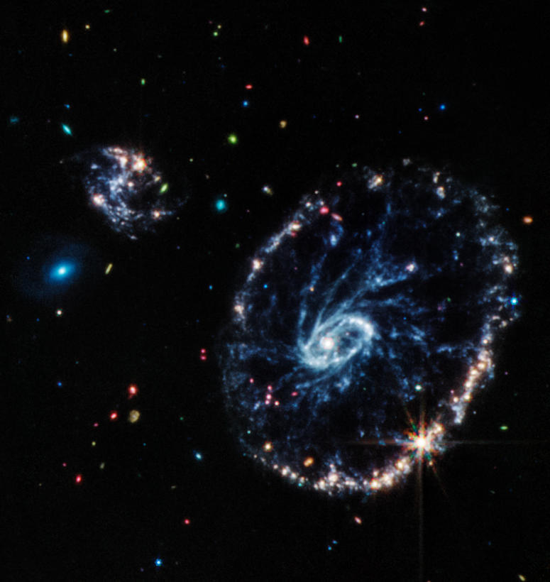 James Webb показал галактику Колесо Воза за облаком космической пыли